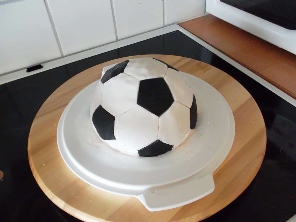 an image of a black and white soccer ball cake on a stove