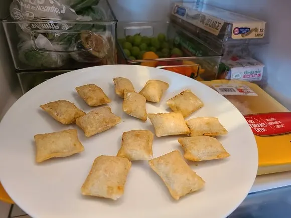 an image of thawed pizza rolls on a plate in a fridge