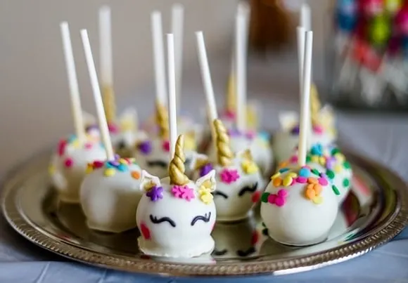 several unicorn cake pops on a small plate