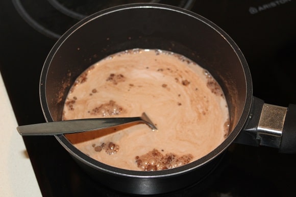 a saucepan with hot milk and cocoa powder in it