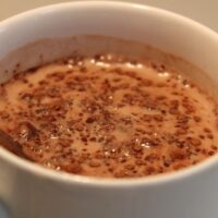 a mug with hot chocolate with cocoa clumps