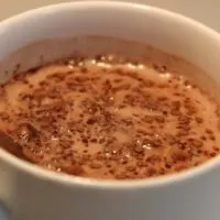 a mug with hot chocolate with cocoa clumps