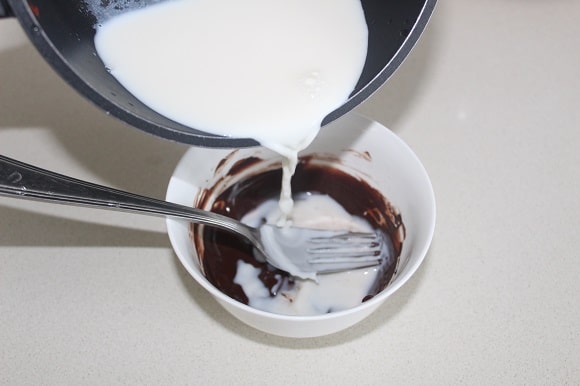 cocoa powder being mixed with warm milk