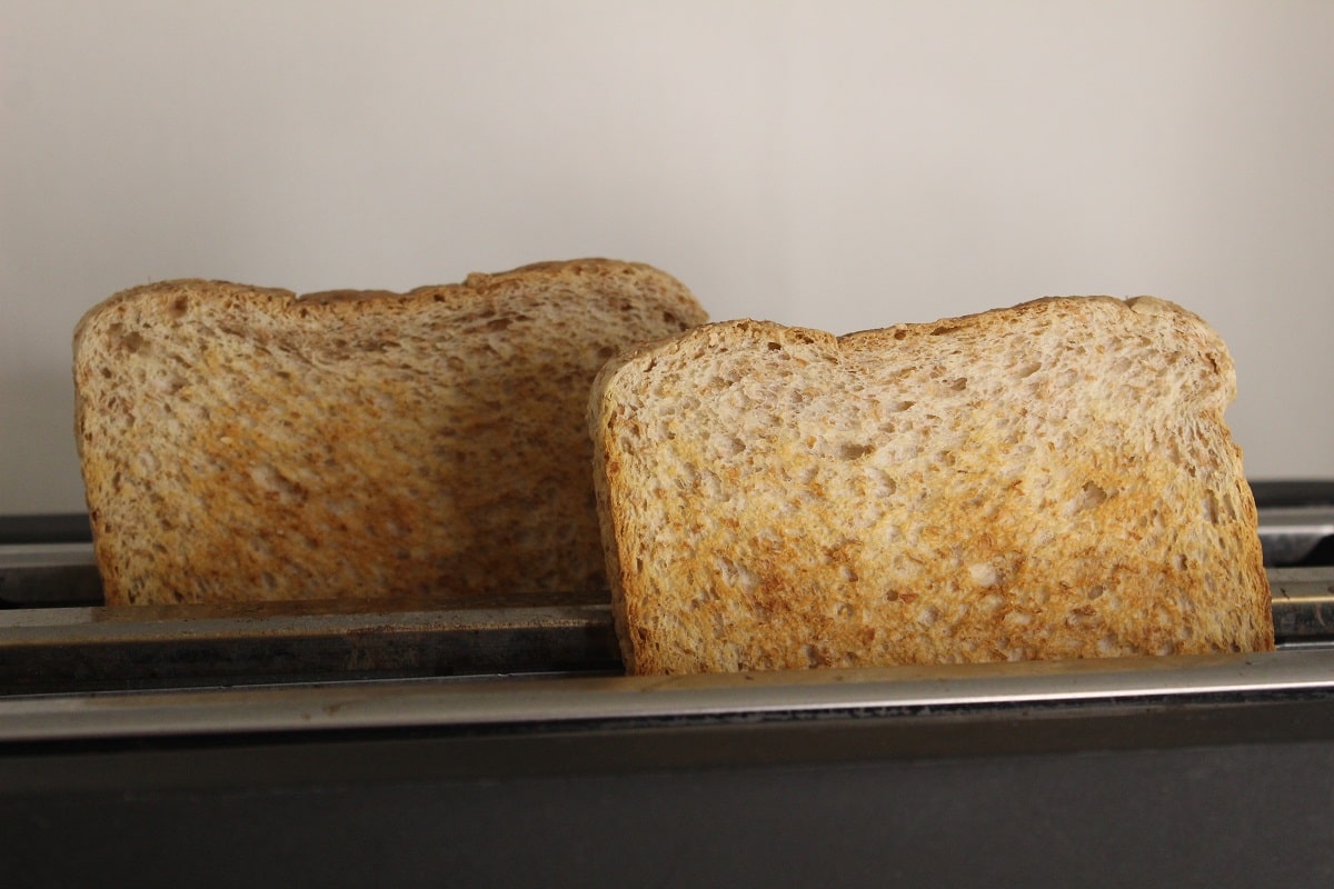 two slices of toast bread coming out of a toaster