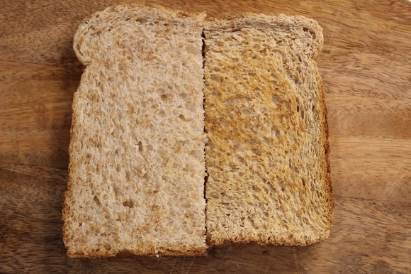 a half slice of untoasted bread next to a half slice of toasted bread