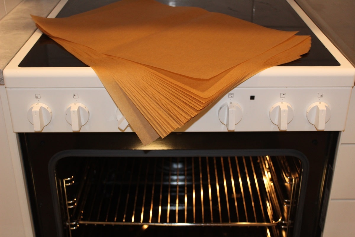 a stack of parchment paper lying on top of an oven in a kitchen