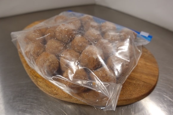 a bag of frozen meatballs thawing on the kitchen counter