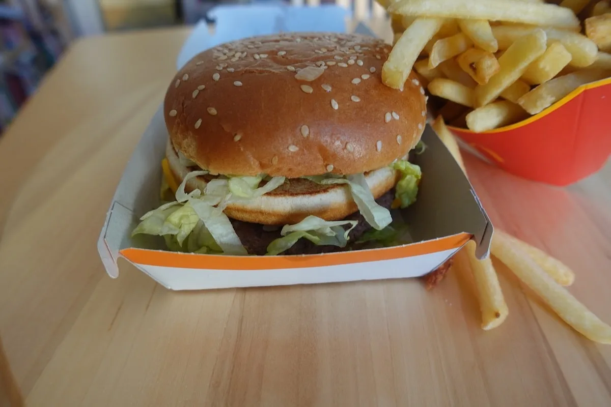 a mcdonald's big mac next to some french fries on a table