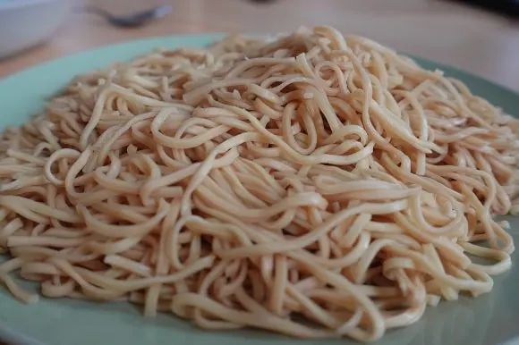 a plate with freshly cooked noodles on the dinenr table